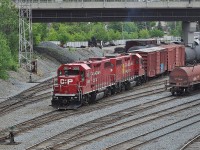A pair of CP GP38-2s, 3085 and 3021, are bashing cars around in CP's small Sudbury, Ontario yard under the Paris Street bridge.