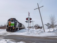 One of the first empty cement train trips on the Chandler subdivision slows down to a halt in order to manually protect the crossing of Maldemay Street and 3rd Avenue, which will require new equipment before being activated.
As the train approches the crossing, a couple of bystander stops to watch the train go by. It was the first one they were seeing on over a decade! They weren't the only ones i had met on this trip, in nearly every town located along the track, atleast one person paused their joywalk in order to watch the train go by, needless to say, the locals really liked their train, and it shows when you see how hard they are fighting for VIA Rail to come back.
Sadly, a few weeks after i took this picture, the old telepgraph poles to the right were cut down, maybe they leaned down a bit too much for comfort... It was one of my favourite features of this spot, so even though the weather was pretty disapointing for photos, i'm glad i got this picture in the end...