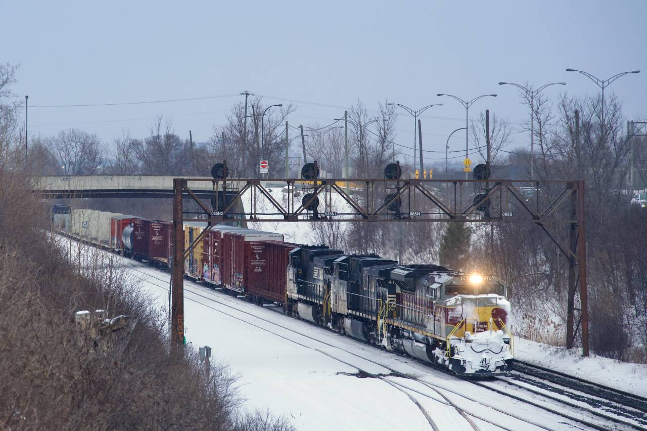 On a wet and dark morning, run-through train CN 529 has the Lackawanna heritage unit leading as it prepares to enter Taschereau Yard after a short delay. Fourty minutes later I would shoot CP 7018 leading CPKC 2114.
