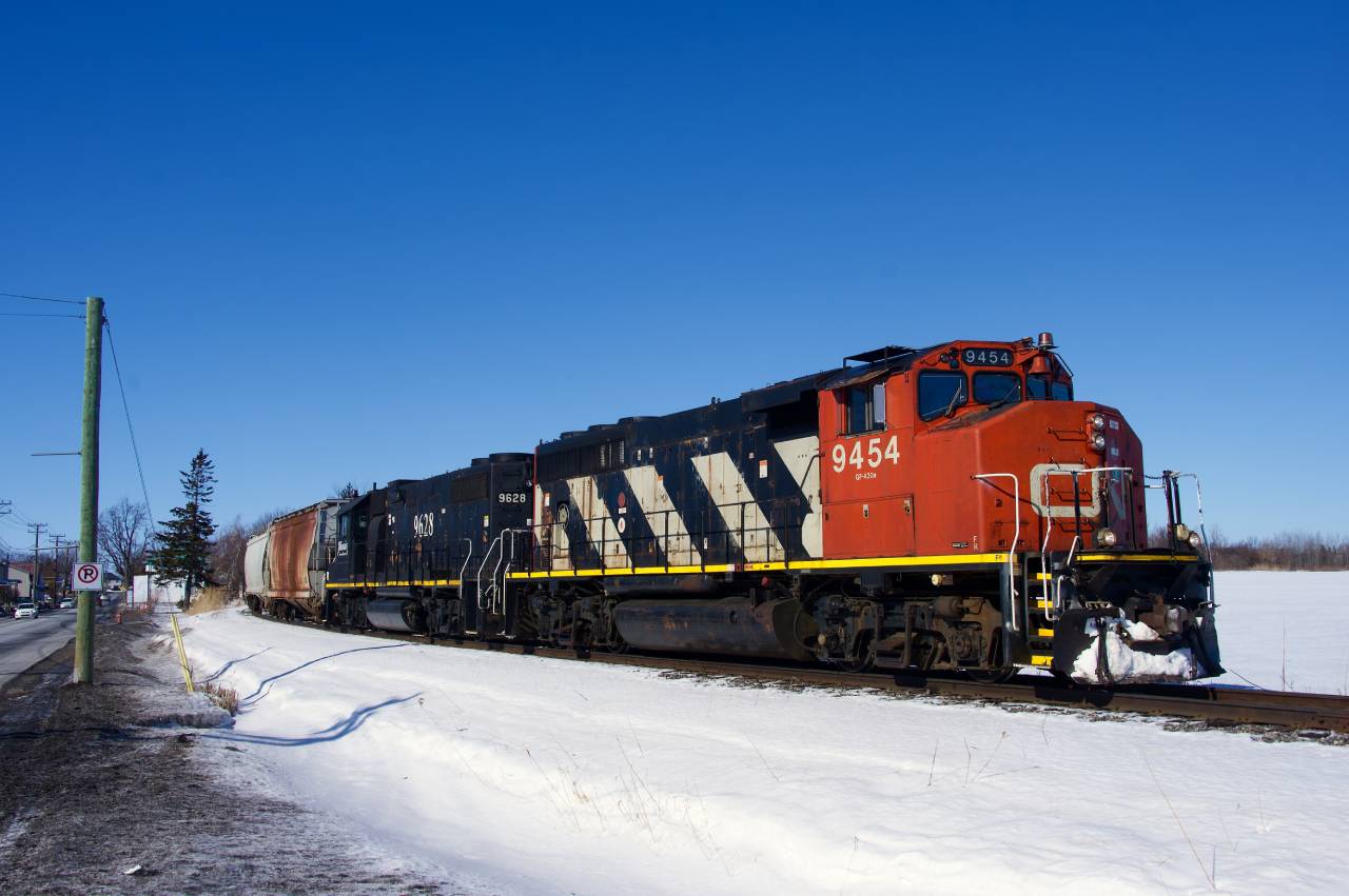 CN 589 is backing up on the Valleyfield Sub in Coteau before heading back towards Ottawa. Power is CN 9454 & IC 9628.