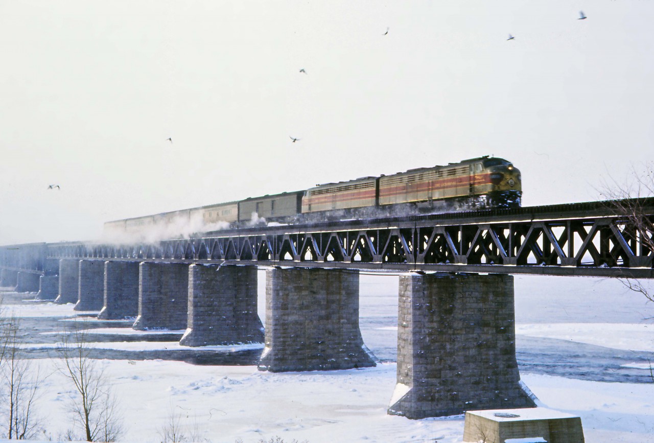 Operating as No. 221 on CP’s Adirondack sub, Delaware & Hudson’s Montreal Limited crosses the St. Lawrence River on its way to a scheduled 8:30 AM arrival at Windsor Station. Having departed Grand Central Station at 10:30 PM as part of Penn Central Train No. 63, the consist was turned over to the D&H at Albany-Rensselaer departing at 2:15 AM as its train No. 9. The same October 26, 1969 PC timetable describes accommodations as “Lounge Sleeping Car Bedrooms New York to Montreal (Beverages and Buffet Breakfast)",  "Sleeping Cars  Roomettes and Bedrooms New York to Montreal", and  "Reclining Seat Coaches Between all points”. Why the Erie Lackawanna E8s? Between mid-1968 and mid-1972 (after the EL bankruptcy), both D&H and EL were operated under common management in a holding company (DERECO) controlled by the Norfolk & Western. EL E-units were often used on the Montreal Limited and the Laurentian when PAs weren't available or additional steam heating capacity was deemed necessary.