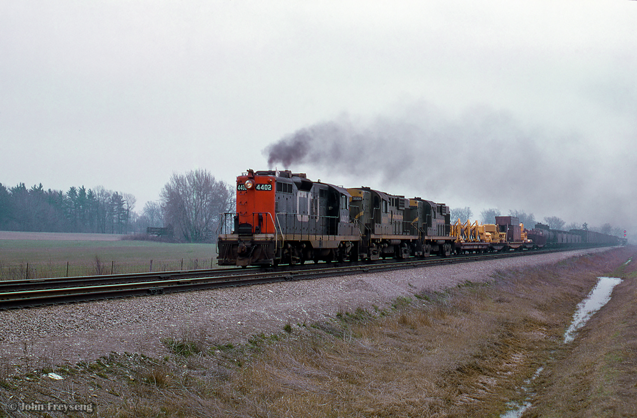 The hogger of CN Extra 4402 East has the throttle wide open getting his this train up to track speed through Speyside. 

Scan and editing by Jacob Patterson.