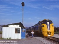 How the mighty have fallen: the once grand <a href=http://www.railpictures.ca/?attachment_id=36087><b>CN Parkdale Station</b></a> has been replaced with this CN trainorder shack, at the junction with CN's Weston Sub and Newmarket Sub. Ontario Northland train #123, the "Northlander", is seen paused beside it waiting to head up the Newmarket Sub after departing downtown Toronto (timetables show #123 was due at Parkdale at 7:08pm, Friday & Sunday only). ONT FP7 1984 leads its TEE trainset consist. In the background is the upper portion of CP's own Parkdale Yard.
<br><br>
The original Parkdale Station was built in 1878 by the Northern Railway of Canada, and closed by CN in 1976. Facing demolition, a local station preservation group sprung up and got the station moved to Sunnyside, where it was unfortunately lost to fire by vagrants. Information on this replacement is scant - it's unclear how long this trainorder station shack or the operator based here lasted, possibly into the early-mid 1980's. Timetables mention it governed all movements to/from the Weston Sub to the Newmarket Sub. It looks like <a href=http://www.railpictures.ca/?attachment_id=22738><b>others have visited it</b></a> in the past as well. Part of the <a href=http://www.railpictures.ca/?attachment_id=43465><b>CN freight shed</b></a> on the left apparently became a fruit market in later years, and survived into the mid-2000's before demolition.
<br><br>
<i> Peter Jobe photo, Dan Dell'Unto collection slide.</i>