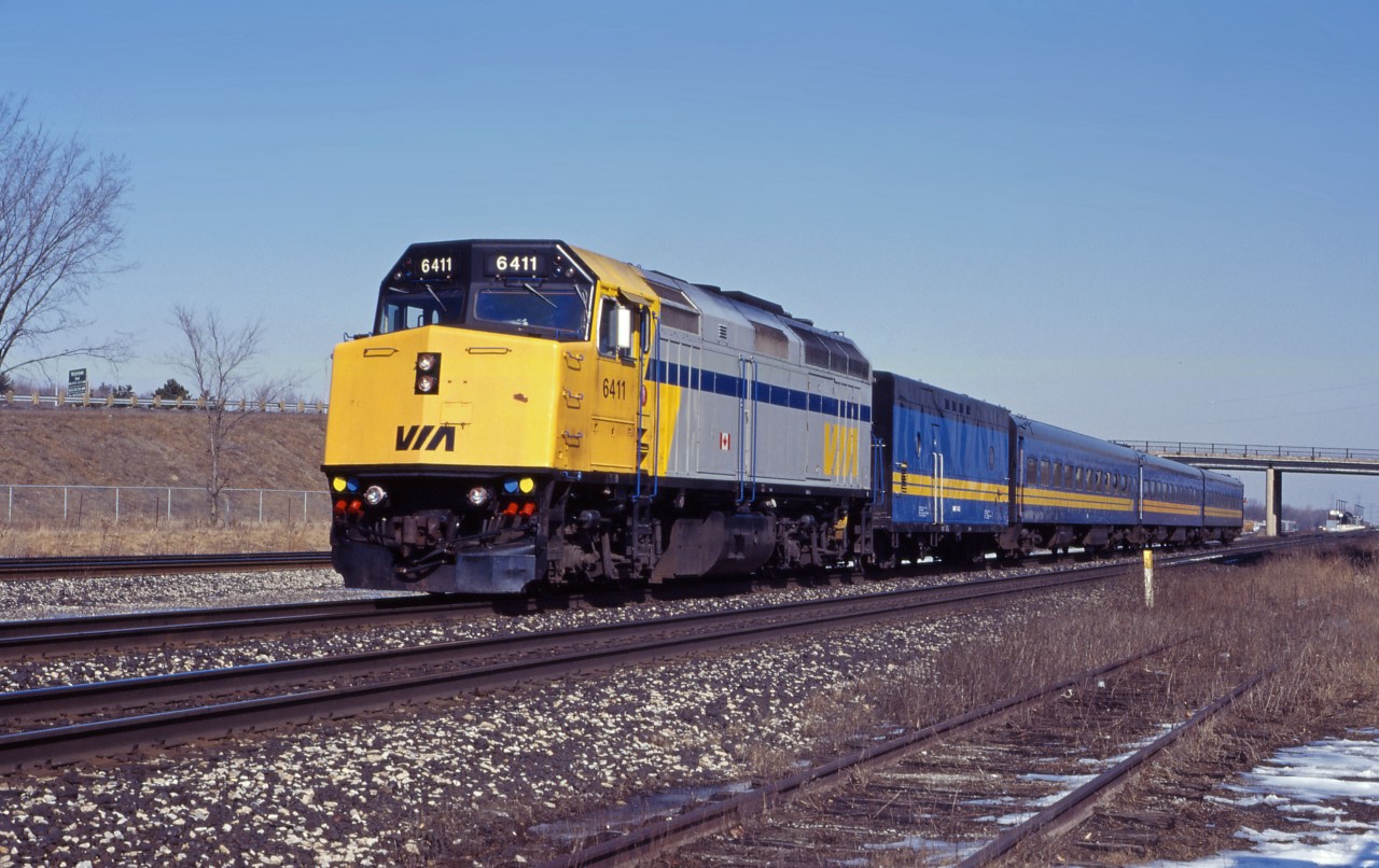 F40PH-2 6411 leads VIA No. 73 away from its stop at Aldershot early in 1995. The former CN "blue cars" and steam generator are rolling off some of their final miles; within a year, head end power ("HEP-2") stainless steel will replace them on Toronto-Windsor trains. (At the time of the photo, HEP-1 cars were normally used on the Niagara Falls trains.)