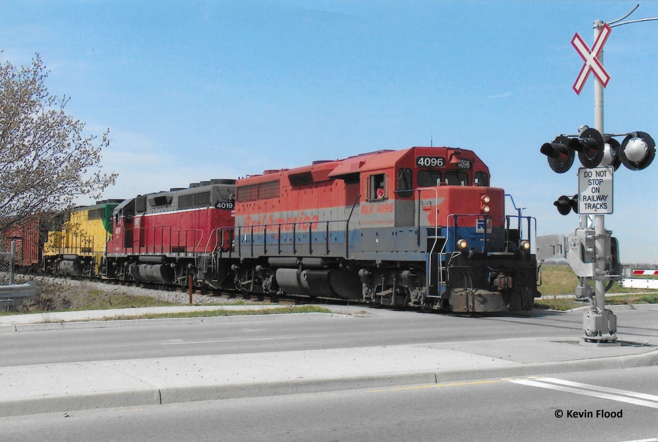 On a pleasant spring day in April 2006, GEXR 432 heads east out of Kitchener, crossing Bingemans Centre Dr., with RLK 4096-GEXR 4019-GEXR 4046 for power.