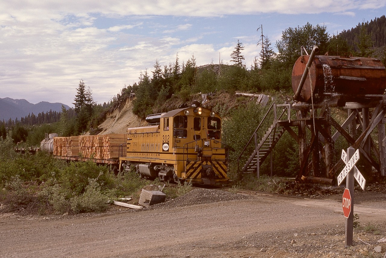 In the years before public road access was provided, logging roads were the alternate way to access timber harvesting communities in the Nimpkish valley on Vancouver Island, and supplies were best transported by rail.  Thus Canadian Forest Products 302 has two carloads of crossties and one tank car of fuel in addition to log empties southward by the road and rail water tank near Duncan reload on the way to Vernon Camp on Monday 1975-06-09.