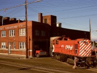 In Victoria, trackage continued past mileage 0.0 at the depot onto Store Street to reach a number of industrial customers, with Swift’s meat packing plant frequently a priority for the yard crew to switch with high-value loads.  On Saturday 1975-07-12, that was the case for MLW S-3 CP 6572 heading out of the spur at Swift Street to Store Street and onward to the Albion Yard distribution area.