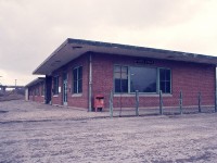 Continuing on with station photos....  This one was familiar with many fans; the old MCRR/TH&B station at Fort Erie. It was known by most photographers as that modern (1949) boarded up brick building that sat abandoned on the north side of the tracks near the International Bridge.  Once the TH&B dayliners ceased operation in spring of 1981, the building outlived its usefulness.  It was demolished in 2000.
Note the newspaper box for the Globe and Mail.  The price was 10c per copy. It is now $5.25. !!!