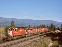 With dynamic brakes whirring, a loaded coal unit train from southeastern BC with CP 5811 + 5812 + 5772 + 4572 on the headend and unseen mid-train remotes 1017 + 5703 + 5642 + 5599 is descending from Notch Hill on the Shuswap sub. on Sunday 1976-10-17.  The era of exclusive MLW power on CP coal trains was long gone.

