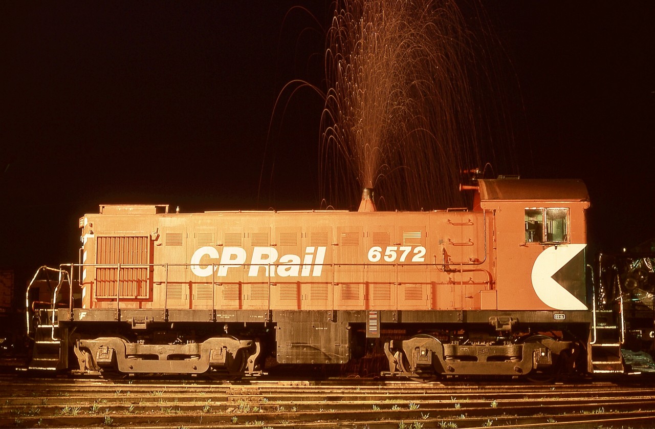 On the E&N on Monday 1979-03-12, MLW S-3 CP 6572 had recently returned from Port Alberni to Victoria roundhouse for scheduled maintenance and was lined up for the 0600 Victoria yard job.  A personal practice was to work the engine against full-set airbrakes to verify loading and to warm up the wheels for good braking, out from the turntable and back several times within the tenth of a mile of shoptrack, that on Monday mornings particularly desirable after a Sunday parked in the shop.

Extensive idling at Port Alberni had accumulated quite a bit of carbon in the exhaust, and the heat from my load testing caused it to be emitted as a magnificent show of sparks, caught with a time exposure of several minutes.

Note the as-built single note “honker” air horn, and above it a three-note added at Victoria for better sound projection operating in reverse over the many local crossings, and coincidentally, a more pleasant sound overall.