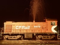 On the E&N on Monday 1979-03-12, MLW S-3 CP 6572 had recently returned from Port Alberni to Victoria roundhouse for scheduled maintenance and was lined up for the 0600 Victoria yard job.  A personal practice was to work the engine against full-set airbrakes to verify loading and to warm up the wheels for good braking, out from the turntable and back several times within the tenth of a mile of shoptrack, that on Monday mornings particularly desirable after a Sunday parked in the shop.

<p>Extensive idling at Port Alberni had accumulated quite a bit of carbon in the exhaust, and the heat from my load testing caused it to be emitted as a magnificent show of sparks, caught with a time exposure of several minutes.

<p>Note the as-built single note “honker” air horn, and above it a three-note added at Victoria for better sound projection operating in reverse over the many local crossings, and coincidentally, a more pleasant sound overall.