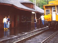 What a dismal dark day to be watching trains in Parry Sound. But, I'm there. Have to make the best of it. Even getting a decent setting with a film camera was difficult, which is obvious against this dark building.
Its been almost 40 years since this image and I have forgotten the name of the feller passing up the orders as this northbound train roars by.  Interesting old time scene.