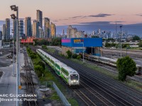 GO At Sunset. On the evening of June 27, 2022, GO Transit 306 (Bi-Level IX Cab Car, Bombardier) led a ten-car train by the yards near Islington Avenue in Toronto, Ontario. The Toronto Skyline is an attraction in and of itself, with the CN Tower keeping watch since 1976. The ten-car length is not uncommon; GO operates long consists to create high-capacity trains.

 
