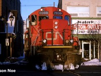 During a late winter evening, the CN 15:30 Kitchener Job is pictured crossing King Street in uptown Waterloo, Ontario with GP9RM’s 7040 and 7039. The units were returning to the Kitchener yard light power after setting-off tank cars in Elmira on the Waterloo Spur. 