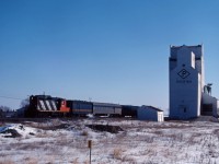 Although normally powered by an ex-CN FP9, occasionally No. 109 would be assigned a GP9 geared for passenger train speeds. Having moved to the prairies after years in passenger service out of Toronto, CN 4103 hustles the typically short train past the elevator at Dacotah (about 25 miles west of Winnipeg) on a cold but bright Saturday morning. In 1984, the 4103 will be chop-nosed and re-manufactured to GP9rm 4104.