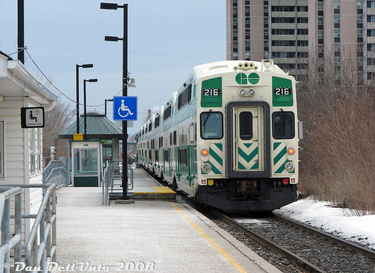 The quintessential image of Weston GO Station, circa mid-2000's: GO Transit cab car 216 trails F59PH 542 on southbound train #260, the "Bramalea Flip", departing Weston Station enroute from Bramalea to Toronto Union Station. After our morning class downtown was over, we just rode the afternoon train from Toronto to Bramalea for fun, then back down and off at Weston to shoot CN #577 hot on our tail (that was spotted switching Malport before the GO trip back south) before making our way back downtown via the TTC's 89 Weston Road bus and Bloor-Danforth subway.

To say Weston GO station was somewhat underwhelming was being generous. The basic tunnel near the underpass off Lawrence Avenue leading up to the platform was typical GO "cold concrete" era architecture, with sparse amenities awaiting above. The small corrugated shack of a station building (that always seemed to be closed), next to the quaint waiting room dating from its CN days as...a waiting room (although decently warm on a winter morning at 7am when everyone was crowding inside, it too also always seemed to be closed except for morning rush hour). A far cry from the grander station present in the 1960's when John Freyseng visited. The surrounds in this part of Weston were also lackluster and somewhat sketchy with apartment buildings, parking garages, a small nearby afterthought of a GO parking lot, old houses and a weedy overgrown yet busy shared CN-CP-GO-VIA freight-passenger railway corridor that was wide open to wander around (a plus to those so inclined). All swept away including the waiting room building (the last vestiges of the ghost of CN's Weston Station) in the early 2010's for a new, larger, more modern station to the south with two separate entrances and more parking, the north one located where the old West End Chrysler Dodge auto dealership was (demolished mid-2000's), and a large grade-separated trench full of tracks to appease the residents of Weston (yet, puzzlingly leaving the busy CP freight line at-grade beside as a thorn in the side of residents for years to come).