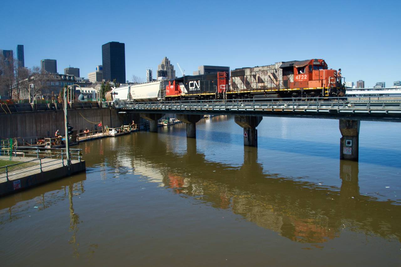 CN 500 is entering the port of Montreal with CN 4722 & CN 4761 for power. The engines are reflected in the high waters where the Lachine Canal empties into the St. Lawrence River.