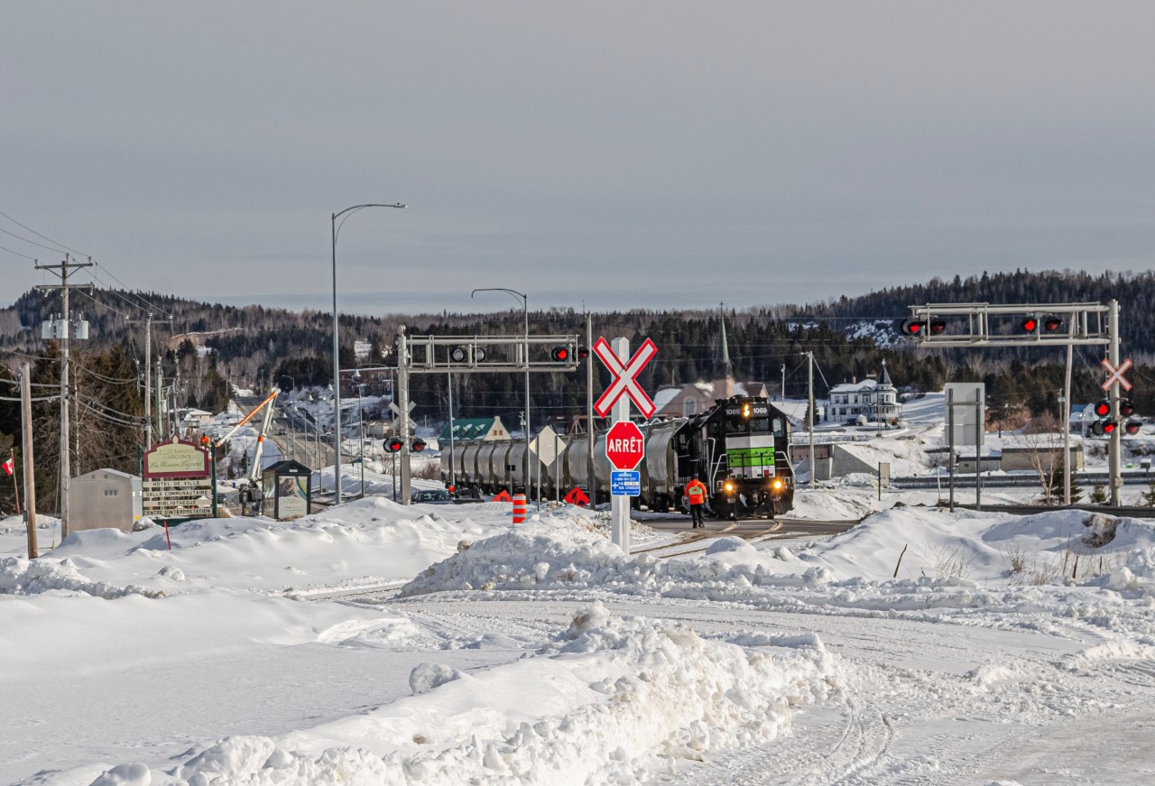 SFG Train 566 manually protects the crossing of Route 132, as they depart from Port-Daniel towards New Richmond with a few loads of cement. The railway had been only reopened almost 2 months prior.