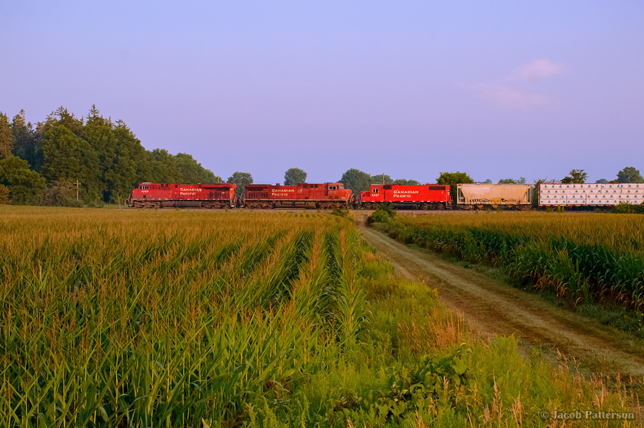 As the morning sun cuts through the haze, CPKC 135 thunders west through the farms of Puslinch.  CPKC 529 follows not too far behind.