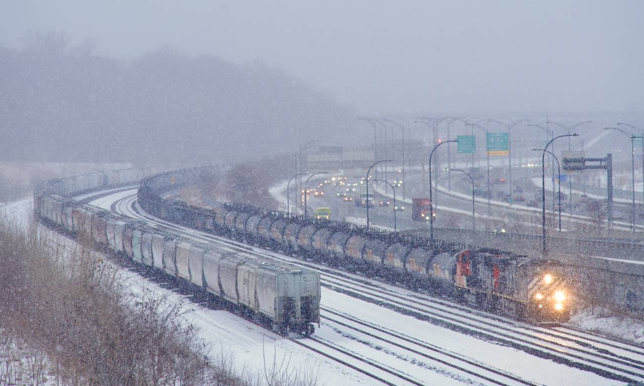 BCOL 4646 leads CN X321 as it approaches Turcot Ouest in the snow. Up front is a string of black TankTrain cars. At left are grain empties from the Port of Montreal that CN 500 had left there earlier in the day.