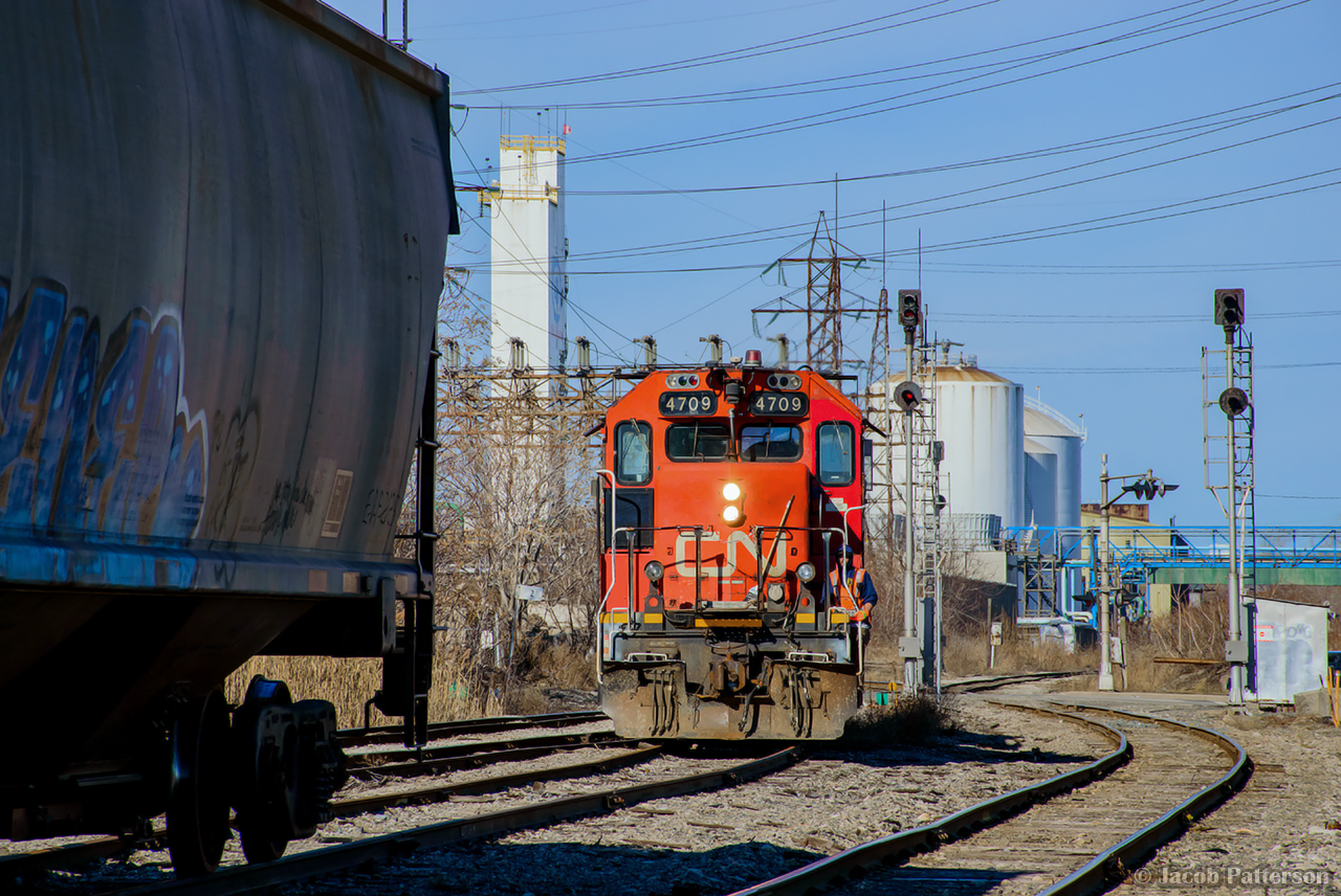 Returning to Stuart Street after working down the hole, an extra 0900 job stops at Gage Ave to lift interchange traffic dropped by CPKC H41 earlier in the morning.