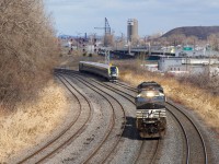 CN 543's light power and VIA 637 are both westbound in Montreal West. CN 543 has the common NS power and is returning from the Port of Montreal after bringing a grain train there.