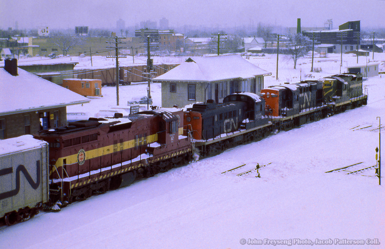 An extra freight bound for Montreal passes through Danforth with an eclectic mix of power on the head end, in the form of a GP9, RS18, RS3, and DMIR SD9.  During the winters beginning 1963-1964 through the winter of 1973-1974, DM&IR SD9s and SD18s were often leased by CN, as well as CP and other lines, to fill out power shortages. The winter of 1965/66 saw CN leasing 20 units.

John Freyseng Photo, Jacob Patterson Collection Slide.
