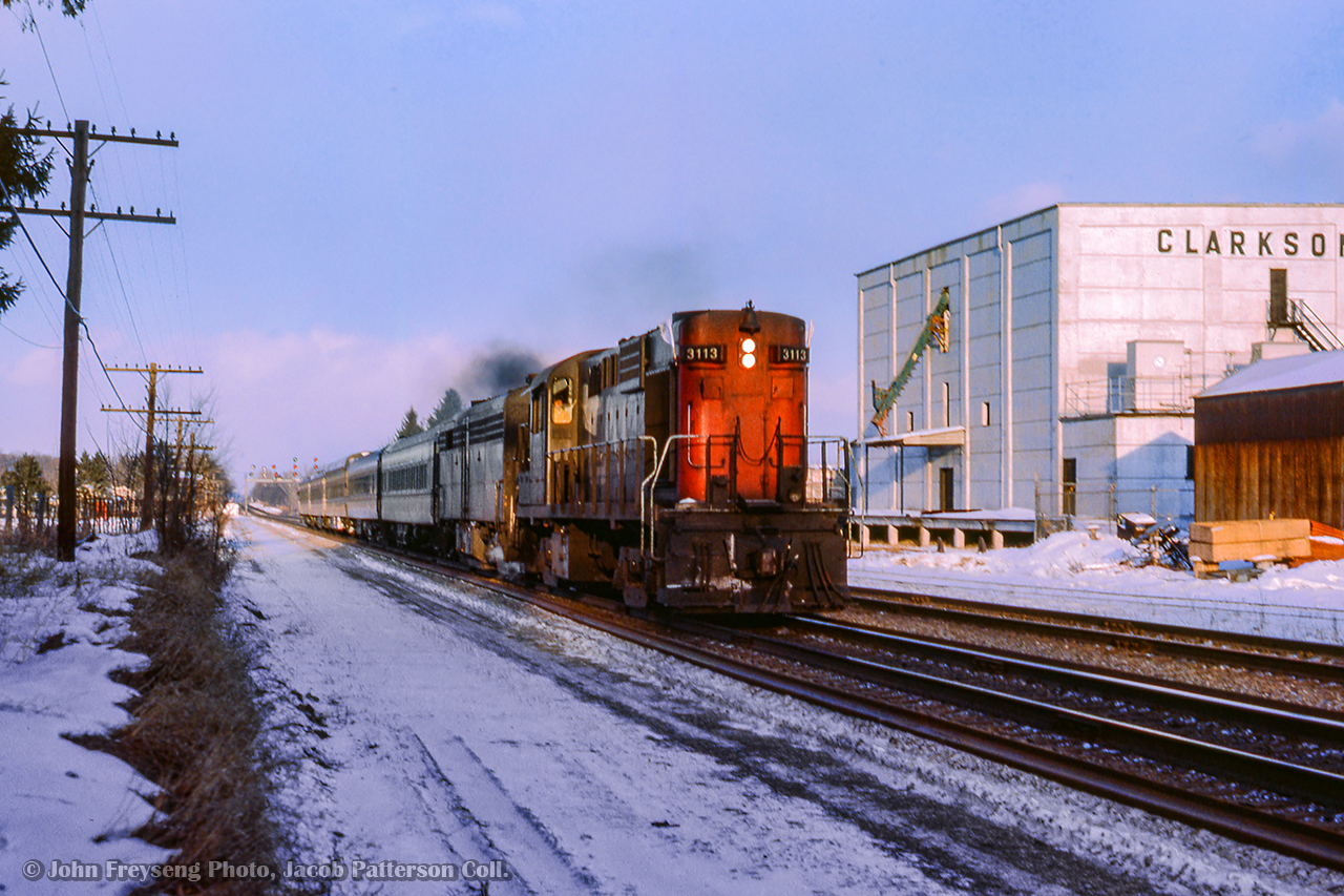 Passing the Clarkson cold storage building, CN passenger extra 3113 west approaches the crossing at Clarkson Road.  The cold storage building and the rest of the property was cleared between 2020 - 2022 for condos.

John Freyseng Photo, Jacob Patterson Collection Slide.
