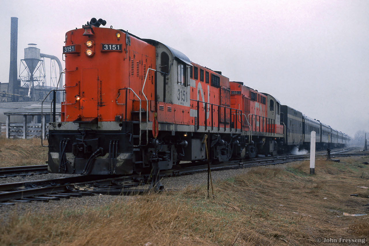 A pair of CN Tempo RS18ms idle away in the rain at Elmira while passengers of the seven car train have alighted to sample the sweet tastes of the Elmira Maple Syrup Festival.

The other side

Scan and editing by Jacob Patterson.