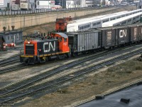 CN 7027 is seen working around Bathurst North Yard, passing an assortment of freight equipment and GO Transit single level cars.  The <a href=http://www.trainweb.org/oldtimetrains/CPR_Toronto/king_st_lead.htm>CPR spur along the south edge</a> of Front Street can be seen, climbing to street level at Spadina Ave, and crossing north to their <a href=http://www.trainweb.org/oldtimetrains/CPR_Toronto/King_Street.htm>freight sheds at King Street (closed 1977)</a> and a few small customers.  CNR's shed, <a href=http://www.trainweb.org/oldtimetrains/photos/cnr_facilities/Toronto_sheds.htm>located on the block south of CPR's,</a> was accessed via a similar spur, just east of Spadina.

<br><br><i>Scan and editing by Jacob Patterson.</i>