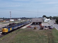 The"Canadian" makes its station stop at Portage la Prairie on a beautiful summer afternoon in 1984. Although the "Panorama" now runs Winnipeg-Edmonton (and three days per week to Prince Rupert), No. 1 is still handling the bulk of the transcontinental traffic--normally an 18-20 car train in the summer. Powered by an ABBB set of former CN F-units, just up ahead the Queen of the fleet will take the connecting track between CN and CP to resume its traditional route to the coast. (Also note the freight in the background near CP's Portage la Prairie station, waiting to following the passenger west.)