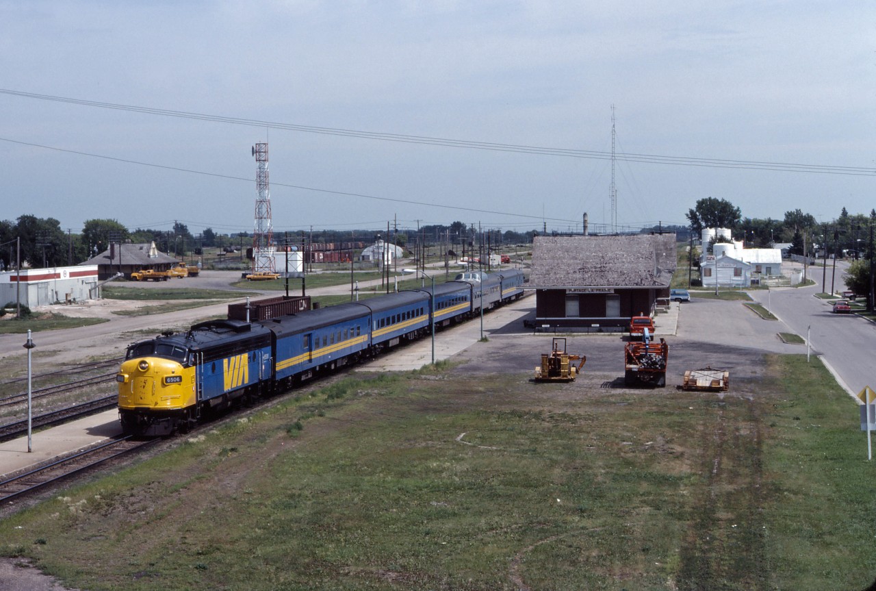 Reviving a name used for the Super Continental’s “running mate” from 24 May 1964 until 6 January 1970, VIA named its Winnipeg-Edmonton-(3 days per week) Prince Rupert train the Panorama when it was introduced on 3 June 1984. The train and name only lasted for about a year, after which the Super was reinstated between Winnipeg and Vancouver (on 1 June 1985--lasting until the Canadian was re-routed over CN lines in the January 1990 cuts). Interestingly, the Panorama was used to test Amtrak Superliners and head-end power over the winter of 1984-85; VIA eventually bought F40PH-2s but decided to convert its existing stainless steel equipment to HEP rather than buying Superliner cars. In this photo from July 1984, we see the Panorama making its early afternoon station stop at Portage la Prairie before continuing west.