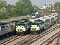 Another warm spring morning down at Bathurst Street, back when you could still taste the morning smog and haze in the downtown Toronto air. Three GO Transit F59PH units swarm Bathurst Street, right where the Oakville Sub ends and the TTR Union Station Rail Corridor begins: 546 is inbound with Lakeshore West train #454, passing 534 trailing equipment move #E472 (off the Lakeshore line) waiting for the light to head westbound to Willowbrook Yard. Unit 543 also lingers in the background on the High Line bypass, on equipment move #E152 (off the Milton line) also bound for Willowbrook and waiting on a light. One had to be on top of things and know what was coming in off what line to get all the train numbers - I had made an Excel "cheat sheet" with every single train inbound or outbound to Union Station, manually scraped from every GO Transit, VIA and ONR schedule, and was usually able to put train numbers to most consists and equipment moves.
<br><br>
A trio of VIA F40PH-3D units pause on #1 "The Canadian", backing a <a href=http://www.railpictures.ca/?attachment_id=14678><b>supersize 30 car train</b></a> inbound to Union Station (with a 4th F40 on the rear, piloting eastward). It's 8:14am now, and the flood of F59's and bilevels at Bathurst Street would die down by 9am, when the pinnacle event of VIA #1 departing Union Station topped off the morning. One would then depart for the day's other work or educational activities, satiated by an hour or two of the morning action.