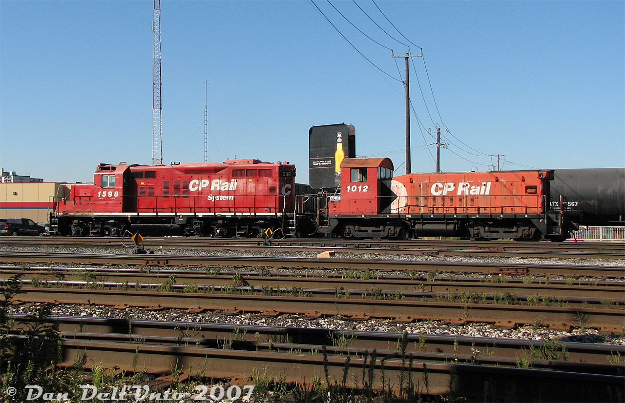 Typical lowly yard power on CP back in the 2000's was often a rebuilt GP9u-slug set. In the 90's CP had a bunch of surplus low horsepower GMD switchers, both aging and underpowered. Converting some into yard slugs was an economical way to reuse old power and give the GP9u's some extra low-horsepower "oompf" around the yard (where low-speed lugging ability was more important than speed or horsepower). Having one less engine between the pair also saved on fuel.

Sitting next to the yard office near the Runnymede Road underpass, CP GP9u 1598 and former SW8u slug 1012 lounge about the afternoon at the split West Toronto/Lambton Yard awaiting their next assignment. There was usually a set here for flat-switching the yard, with local power (typically multiple pairs of GP9u and/or GP38-2 units) parked on another track near Runnymede Park.

The slug conversion was pretty basic: the units would be modified so their traction motors would receive power from the GP9 "mother" unit. The engine block was either left in, or removed and filled with concrete. Cab windows and radiator openings would be plated over or left intact, and painting usually amounted to just a patch job and renumbering. This late in the game, CP wasn't putting any money in the slugs aside from keeping them running, so most wore their old action red colours until retirement (the next year, 1598 got an overhaul and brand new coat of paint, but not a drop was forthcoming for 1012). When this set was retired in 2013, 1598 was traded in on the GP20C-ECO program and scrapped, while 1012 was sold for scrap to SLM Recycling in Welland.