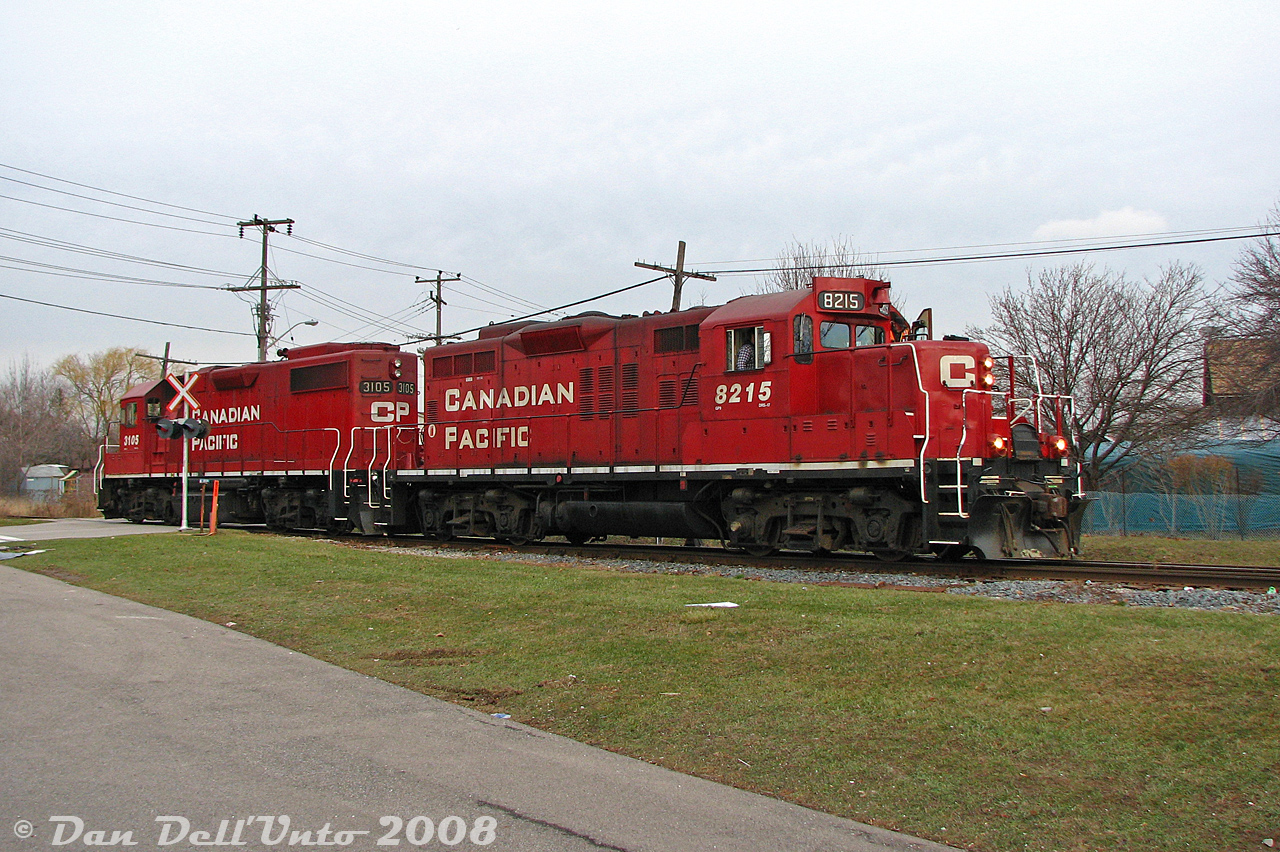 CP on the Owen Sound Sub? Sometimes you just need a bit of luck: I was passing through Streetsville one afternoon and chanced a glance down the CP/OBRY Owen Sound Spur at Mississauga Road crossing - a headlight was visible in the distance! Heading south to the interchange track at Alpha Mills Road for the shot, it turned out it wasn't OBRY;s usual unit, but instead the front of a CP GP9u. Quickly lining up the shot, CP GP9u 8215 and GP38-2 3105 came into view over the grade crossing, working today's Streetsville Turn and coming back from switching the customers at the north end of CP's trackage at Creditview Road. The two units would head down to Streetsville Junction, and proceed to switch the PDI transload facility inside the old wye area west of Mississauga Road. Naturally the weather was rather dour and overcast, (although the grass was surprisingly green for a January winter).

I've heard mention one or both of the CP customers now no longer sees rail service. And of course, the OBRY's operations on the line to Orangeville have passed into history a number of years back. Of the two Toronto-assigned Geeps, GP9u 8215 was lucky to avoid the GP20C-ECO trade-in program and was instead sold to Rail Switching Service. GP38-2 3105 was, as last check, still active elsewhere on the CP system.
