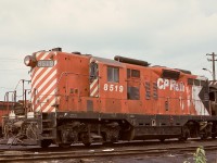 This view of CP 8519 is an example of a steam generator equipped GP9, with the generator exhaust stack and air intake clearly visible, as is one of the two rooftop air main reservoir tanks, as seen on a Coquitlam roundhouse shoptrack on Monday 1975-07-28.

<p>Down on the running board skirt, note the water fill connection a bit forward of the fuel fill point.  And for appreciators of older ways, note the forged handrail stanchions above the running board, as opposed to the newer fabricated ones (likely needed for handrail pull-down repair when separating units with chains still connected) at the front crossover walkway.

<p>Trivia:  To provide sufficient compressed air capacity, there is a third (in addition to the two on the engine hood roof) air reservoir, tucked away out of sight.  Where is it?