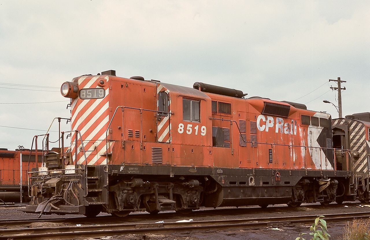 This view of CP 8519 is an example of a steam generator equipped GP9, with the generator exhaust stack and air intake clearly visible, as is one of the two rooftop air main reservoir tanks, as seen on a Coquitlam roundhouse shoptrack on Monday 1975-07-28.

Down on the running board skirt, note the water fill connection a bit forward of the fuel fill point.  And for appreciators of older ways, note the forged handrail stanchions above the running board, as opposed to the newer fabricated ones (likely needed for handrail pull-down repair when separating units with chains still connected) at the front crossover walkway.

Trivia:  To provide sufficient compressed air capacity, there is a third (in addition to the two on the engine hood roof) air reservoir, tucked away out of sight.  Where is it?