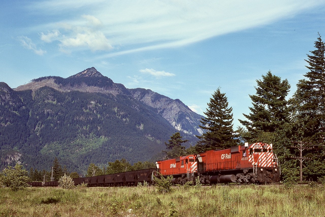 In southwestern British Columbia, we were fortunate to regularly see big MLWs on coal trains to Roberts Bank, due to many of them equipped with Locotrol for controlling mid-train remote units.  On Thursday 1977-06-02 near Agassiz (stated GPS location is approximate), the roar of white flags at track speed heralded the approach of CP 4559 and 4566 (and unseen remotes) on yet another train of coal loads from southeastern BC.