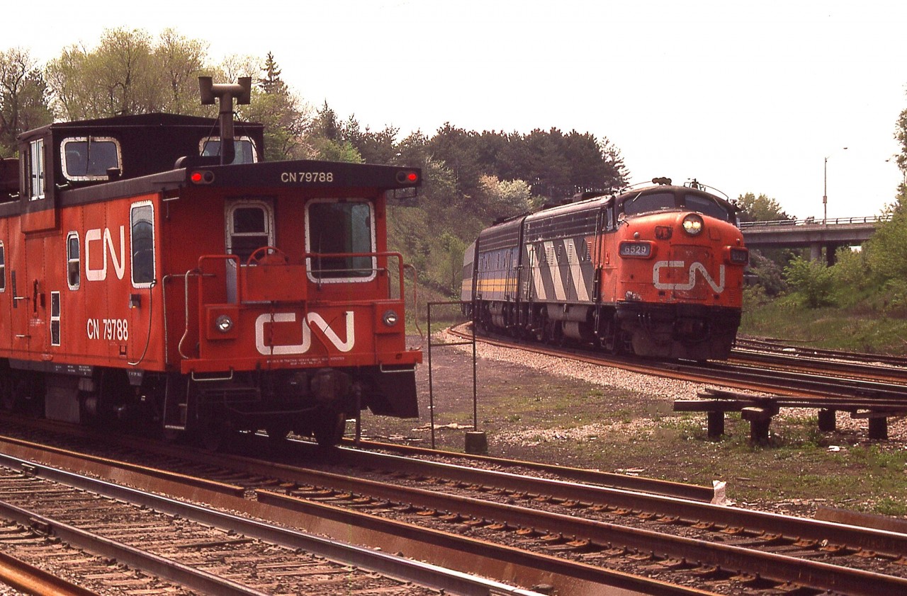 I certainly miss the days when the railroads were busy.  A situation in which two trains can be captured in the same image was not as uncommon as one would think.
Here, an unknown freight is heading into Hamilton while a CN (VIA) eastbound with 6529 & a B unit is about to make its' move.