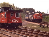 I certainly miss the days when the railroads were busy.  A situation in which two trains can be captured in the same image was not as uncommon as one would think.
Here, an unknown freight is heading into Hamilton while a CN (VIA) eastbound with 6529 & a B unit is about to make its' move.