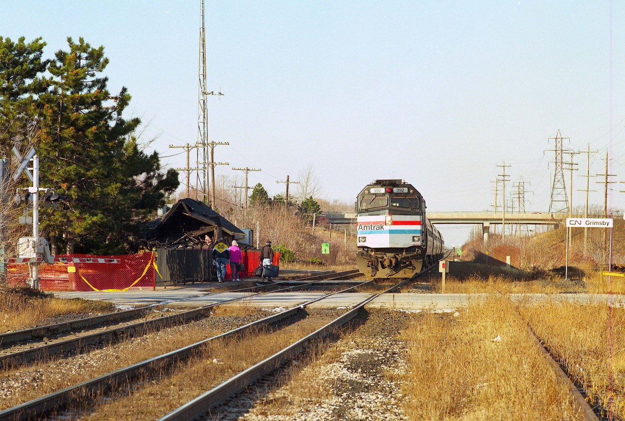 The year 1995 started off on a rather sad note for all rail commuters on VIA and Amtrak who began their day using Grimsby's fancy old station. For on the eve of the last day of 1994, an electrical fire destroyed this well loved landmark.
Here, we see the morning train stopping for passengers who no doubt feel distressed over seeing the remains of one of the most photographed railroad structures in the province.
The board & batten classic didn't stand a chance.  And it was never replaced.