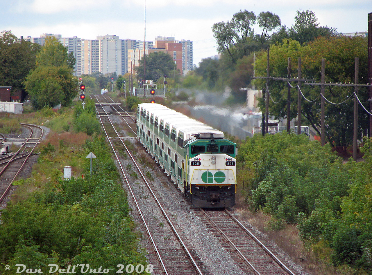 Another spot unrecognizable today: GO Transit F59PH 525 pushes hard on the rear end of fully loaded Georgetown line train #207 (the 4:45pm from Union making all stops to G-town), accelerating from its station stop at Bloor GO and making the run for the CN-CP West Toronto diamond. Cab car 205 has just knocked down the closest signal, and the next at CN Keele beckons the train to enter the single track gauntlet leading to Weston and Etobicoke North. 

Jointed stick rail characterized this stretch of the Weston Sub from Strachan Avenue up to at least the diamond, and the cab car would sometime have a good waddle at speed coming up from Parkdale. The diamonds for CP's North Toronto Sub are visible after the second foreman's crossing in the distance (beyond that is Old Weston Road grade crossing). The vegetation was getting thick around here, but some was pruned for the then-ongoing West Toronto Railpath construction.

It might not look like it, but there was some construction going on for the West Toronto grade separation at the time. Construction in the Junction would pick up in the next few years, and by 2014 a large fly-under trench, a modern signalbridge, welded rail and sound barriers would replace this at-grade stretch of the Weston Sub. 525, one of the first group of F59PH units built in 1988, would be retired and sold to Trinity Railway Express in 2009.
