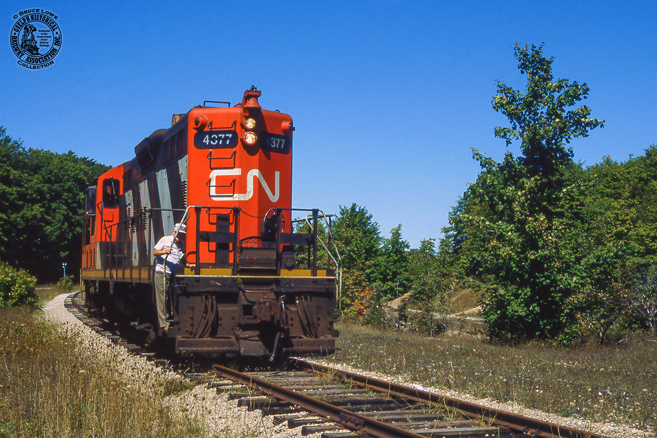 Quiet branchline railroading near Ontario's Saugeen Shores, CN 4377 rolls down the old Southampton Sub main, heading around the wye at Port Elgin. They'll soon lift their train of the south leg and depart for Stratford.

It would appear that the spur, out of frame at left, built in 1970 for the Bruce Nuclear Power Development plant at Douglas Point, was reassigned as the Southampton Sub main at some point. Canadian Transportation Commission Order 35400, issued July 25, 1983, authorized the abandonment* of "b) the Southampton Spur, off mileage 48.19 of the Southampton Subdivision, from a point near Port Elgin (mileage 0.90) to Southampton (mileage 5.00), a distance of 4.10 miles." This of course had been the mainline to Southampton.

*CTC Order 35400 authorized the abandonment of the following lines:
a) the Durham Spur, off mileage 1.3 of the Owen Sound Subdivision, from Whites Junction (mileage 0.00) to Durham (mileage 25.72), a distance of 25.72 miles;
b) the Southampton Spur, off mileage 48.19 of the Southampton Subdivision, from a point near Port Elgin (mileage 0.90) to Southampton (mileage 5.00), a distance of 4.10 miles;
c) the Kincardine Subdivision from a point near Listowel (mileage 1.41) to Kincardine (mileage 57.82),La distance of 56.41 miles; and
d) the Fergus Subdivision from a point near Fergus (mileage 47.00) to a point near Palmerston (mileage 72.00), a distance of 25.00 miles.

Starting around the wye