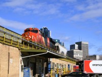 <b> Look up, Look way up </b> <br>
CN 3884 leading a mixed freight consist stalled as it was making its way past the elevated Winnipeg train shed causing a delay in departure of VIA 693 my Winnipeg to Churchill train. <br>
While anxious to get on board and start the journey, this delay allowed for a little more outdoor photo time as well as a delicious lunch at Fergie's Fish & Chips in the refurbished ex-CN Express Garage building at The Forks Market behind VIA Rail's Union Station. <br>
Below the stalled freight is VIA Rail's shipping & receiving dock and warehouse.