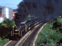 It was a nice, sunny Summer day in Niagara Falls, except for a very dark cloud in the immediate area around Portage Road...<br><br>Canadian National "Bullet-Nose Beatty" 4-8-2 6060 puts on an impressive smoke show leaving Niagara Falls, on one of those Spring-Summer fantrips run from Toronto to Niagara Falls and back. Passengers leaning out of the vestibule doors and baggage car are no doubt getting the full sight, sound, and smell experience of live steam today.<br><br><i>Original photographer unknown, Dan Dell'Unto collection slide.</i>