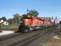 It's SD40-O'Clock at West Toronto as three of CP Rail's many GMD SD40-2 units pound the diamonds heading westbound on the North Toronto Sub, crossing the double track mainline of CN's Weston Sub and the CP MacTier-Galt connecting track. CP 6032 (flying white extra flags) leads 6030 and another unknown 6000 on the north track, while further back on the south track past Osler there appears to be a local freight approaching, lead by an SW1200RS.
<br><br>
The old West Toronto diamonds here, dating back to the <a href=https://www.railpictures.ca/?attachment_id=16093><b>steam era</b></a>, would see many more SD40-2's cross before they were removed after the Metrolinx/GO Transit West Toronto grade separation project was complete in May 2014.
<br><br>
<i>Original photographer unknown, Dan Dell'Unto collection slide.</i>