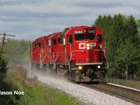 An extra CPKC Wolverton Job with GP38-2 3040 and GP20C-ECO's 2307 and 2259 is pictured heading westbound at Mile 65 on the Galt Subdivision, approaching Ayr, Ontario. The crew is returning to Wolverton after setting-off auto racks on the Waterloo Subdivision for the Toyota Plant in Cambridge, with a stop at Ayr ahead to switch FS Partners on the Ayr Pit Spur. June 1, 2025.