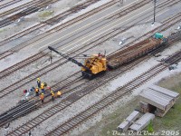 Toronto Terminals Railway crews take advantage of the afternoon lull in GO train traffic to replace the frog on a slip switch east of Toronto's Union Station, on one of the ladder tracks by Scott Street Interlocking Tower. Crews work to secure the newly installed frog and take care of any other work as TTR's yellow Pyke crane idles nearby, having lifted the old frog out and aboard boom idler flatcar CP 302839, and placed the new frog in its place.
<br><br>
The small yellow TTR Pyke crane had been a fixture in the corridor for years, puttering around loading rails, changing out switches and doing general maintenance work. As far as research shows, this particular Pyke crane had been in use around Union Station since the 1980's (photos show it previously lettered for GO Transit, taking down the old Strachan Ave crossing tower). The old flatcar, a cast-off from CP (still lettered for CP, and with friction bearing trucks!) was used by TTR for work service for many years, and continued in use after the Pyke crake was donated to the Toronto Railway Museum nearby.
<br><br>
Other neat stuff from the 15th floor:<br>
CN freight with nice power <a href=http://www.railpictures.ca/?attachment_id=30308><b>http://www.railpictures.ca/?attachment_id=30308</b></a><br>
Ontario Northland's Northlander departing over Yonge Street: <a href=http://www.railpictures.ca/?attachment_id=6975<b>http://www.railpictures.ca/?attachment_id=6975</b></a><br>
A VIA "J-Train" departing the train shed: <a href=http://www.railpictures.ca/?attachment_id=12173><b>http://www.railpictures.ca/?attachment_id=12173</b></a><br>