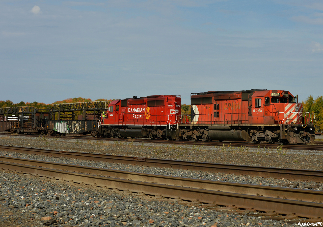 CP 6045 and 6043 sunning in the yard at Cartier as the Conductor slaps a brake on, finishing a long day of dropping rail West of town on the Nemegos sub.