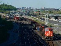 Fresh CN 8310 leads CN 321 past Turcot Ouest, with CN 527's tail end visible at left.